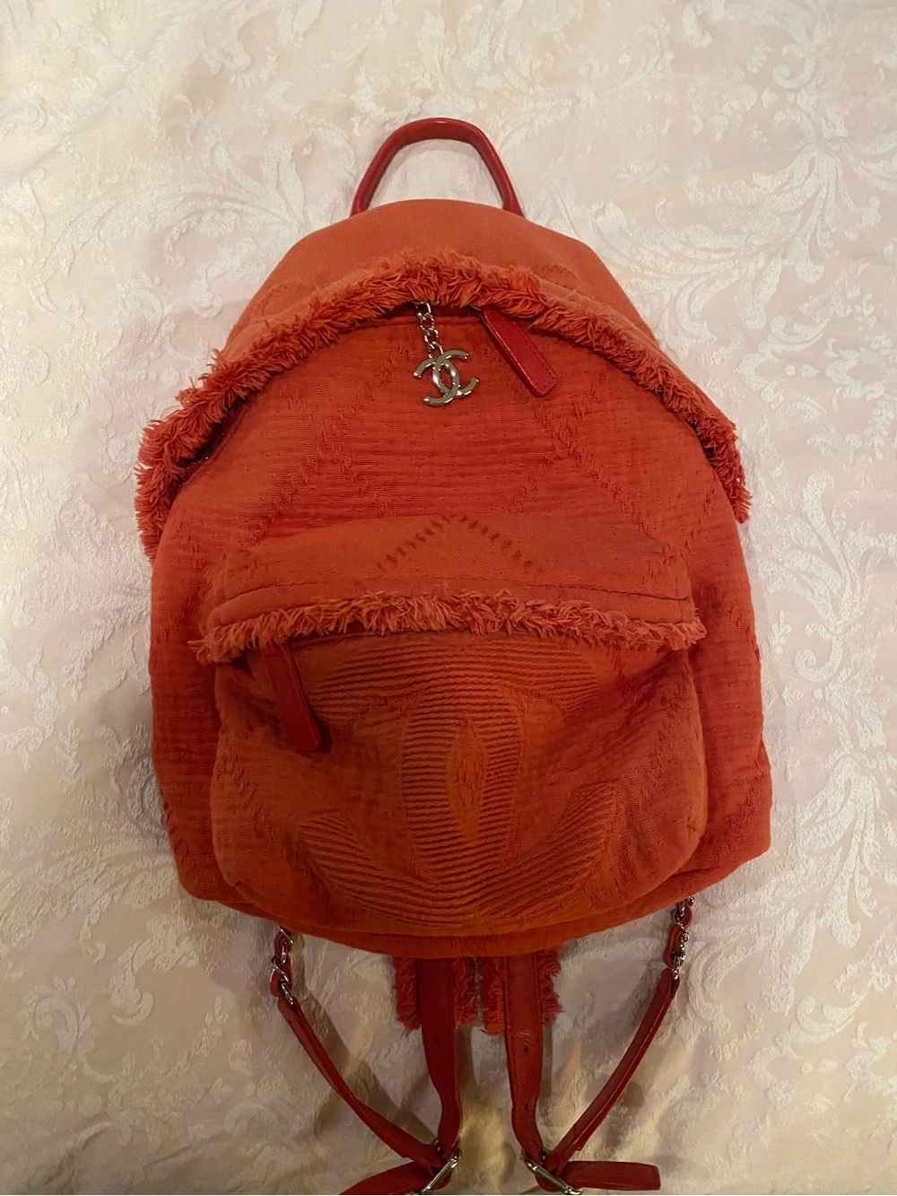 CHANEL Red-Orange Textured Backpack with CC Charm